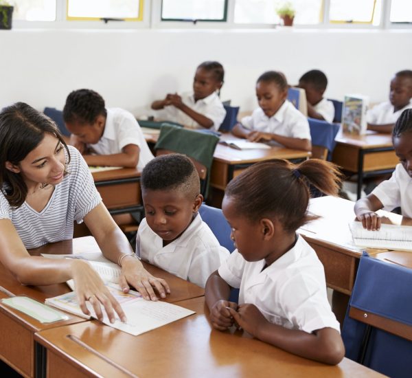 volunteer-teacher-helping-school-kids-at-their-desks.jpg